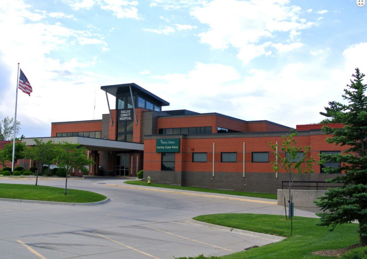 A view of a hospital building with an entrance and surrounding greenery.