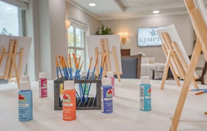 A collection of art supplies including paints and brushes set up for a painting session.