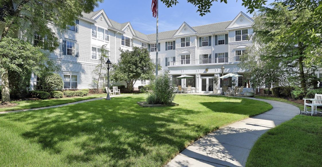 A residential building with a well-maintained lawn and garden area.