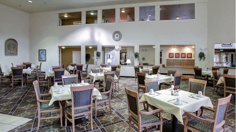 An empty dining area with neatly arranged tables and chairs, ready for guests.