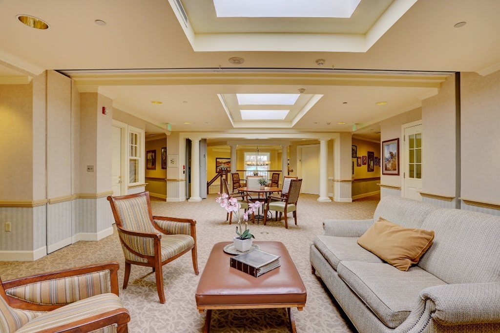 A spacious and bright living room with elegant furniture and skylights.