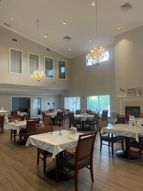 Spacious dining area with elegant chandeliers and neatly arranged tables.