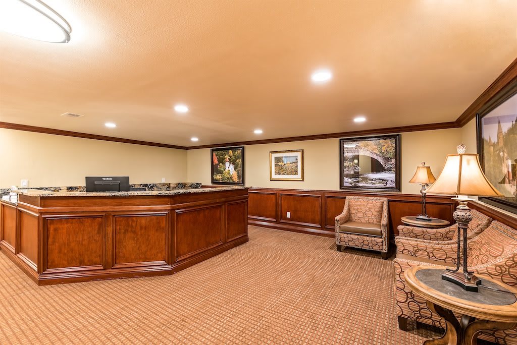 An elegant reception area featuring a wooden desk and comfortable seating.