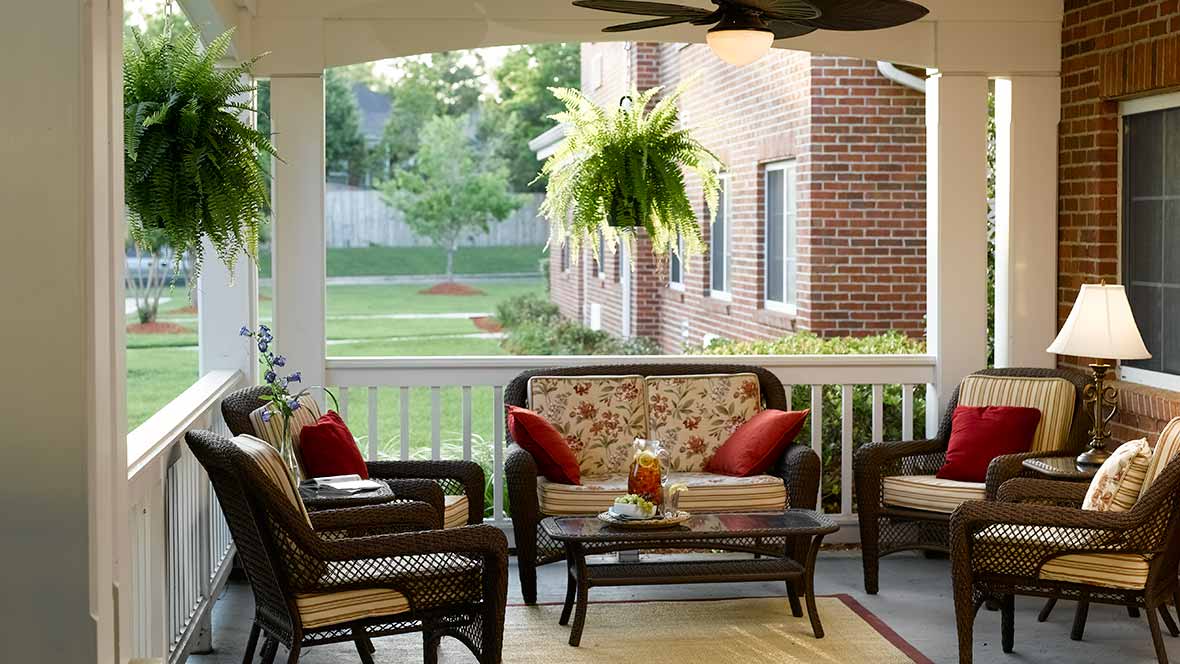 A cozy outdoor patio with wicker furniture and a beautiful garden view.