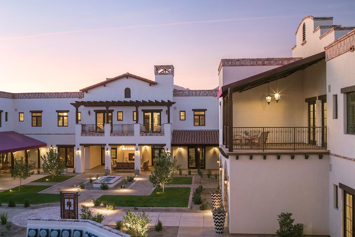 A beautiful Mediterranean-style home with a courtyard, photographed at twilight.