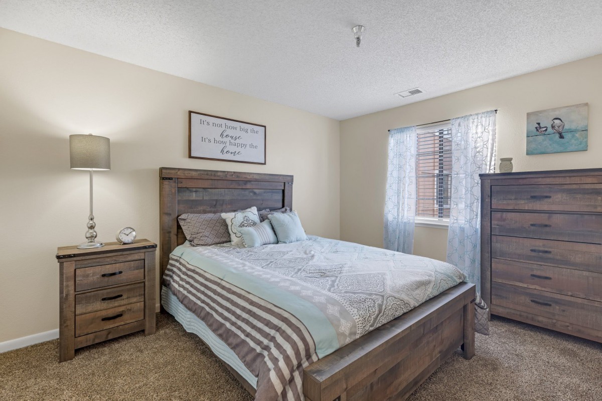 A cozy, modern bedroom with a wooden bed frame and matching furniture.