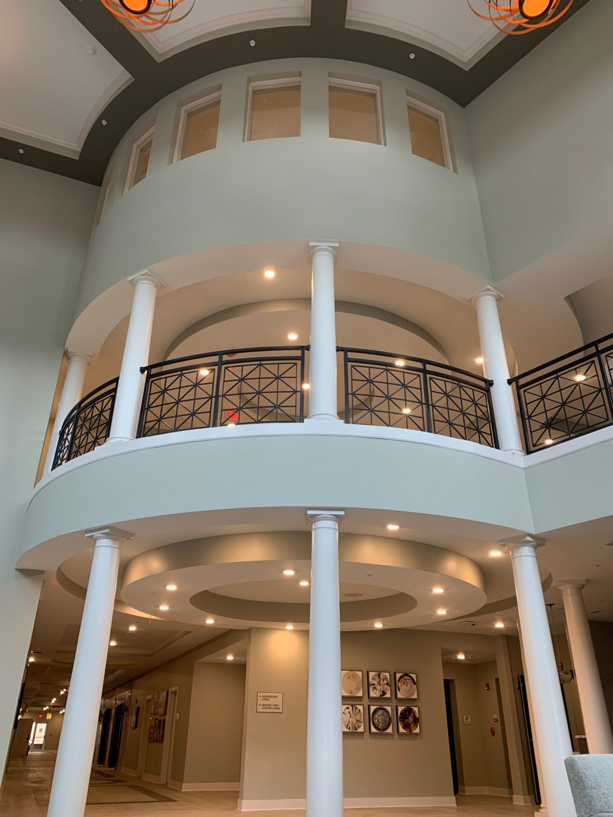 A luxurious interior featuring grand columns, a decorative balcony, and elegant lighting.