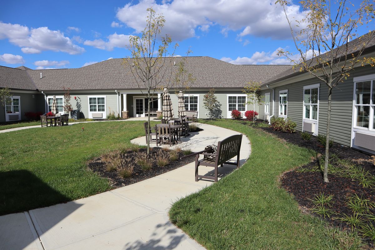 A landscaped courtyard with benches and pathways in front of a residential building.