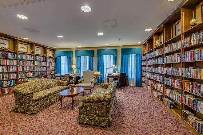 A cozy library with bookshelves, comfortable sofas, and a reading area.