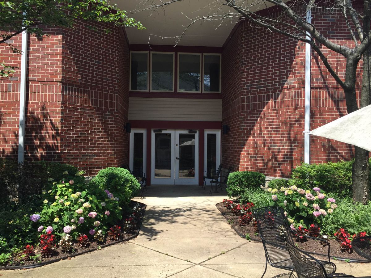 A building entrance with a brick exterior and well-maintained landscaping.