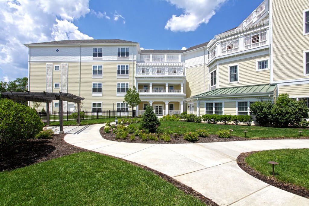 A modern residential building with well-maintained landscaping and a paved walkway.