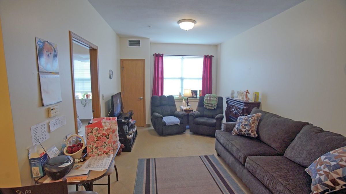 A cozy living room with a sofa, armchairs, and a television.