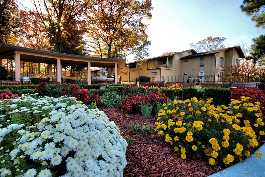 A beautifully landscaped garden with colorful flowers in front of a large building.