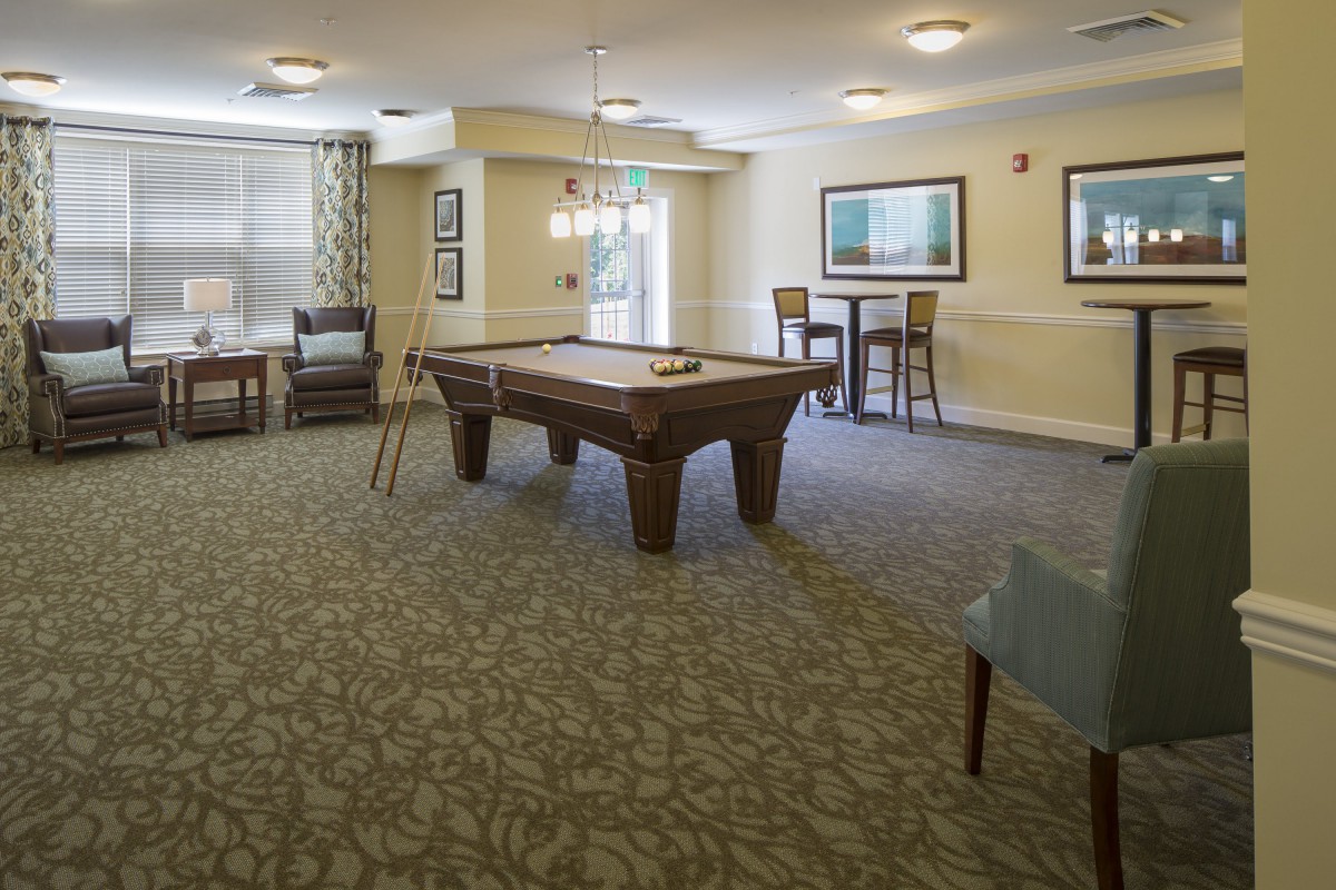A cozy game room featuring a pool table and comfortable seating.