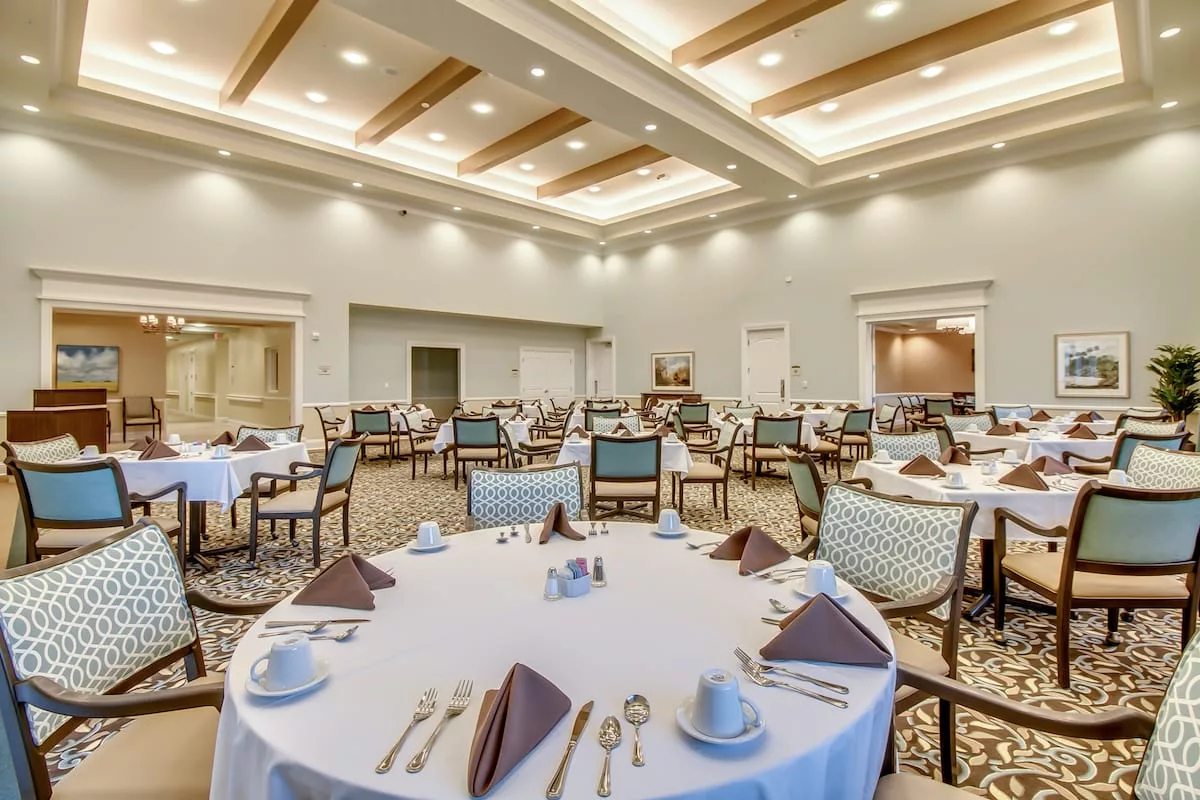 An elegant dining room with neatly arranged tables and place settings, ready for guests.
