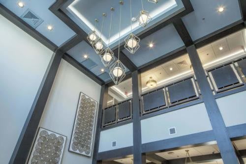 A modern interior space featuring a geometric chandelier and high ceilings.