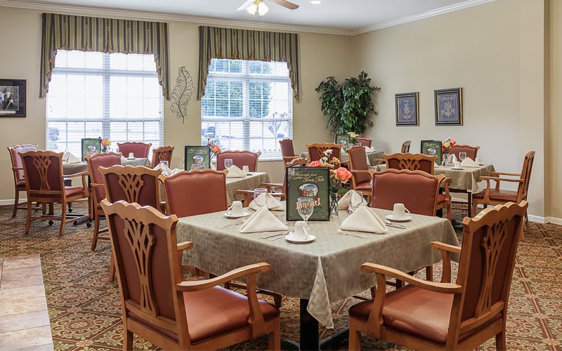 A well-arranged dining room with elegant table settings and comfortable seating.