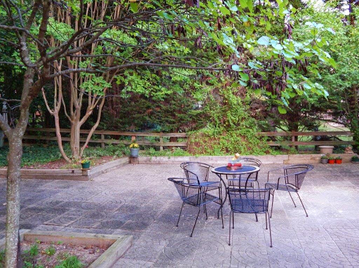 A peaceful outdoor patio surrounded by greenery, perfect for relaxation.