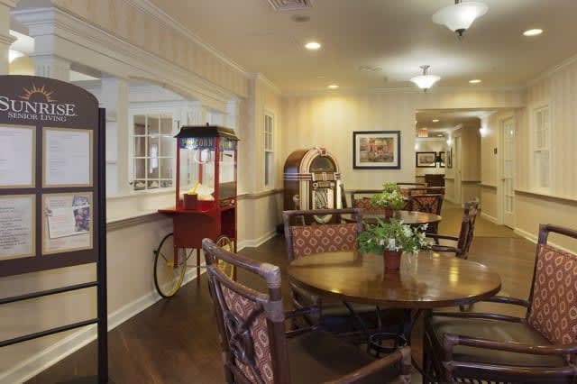 A cozy dining area featuring a popcorn machine and jukebox, with a table and chairs arranged for comfort.