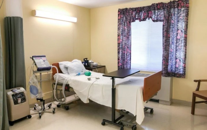 A tidy hospital room with a medical bed and attached equipment.