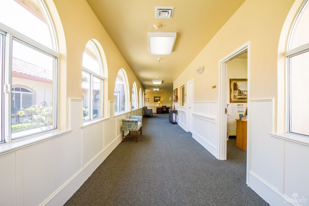 A bright hallway with arched windows and yellow walls.