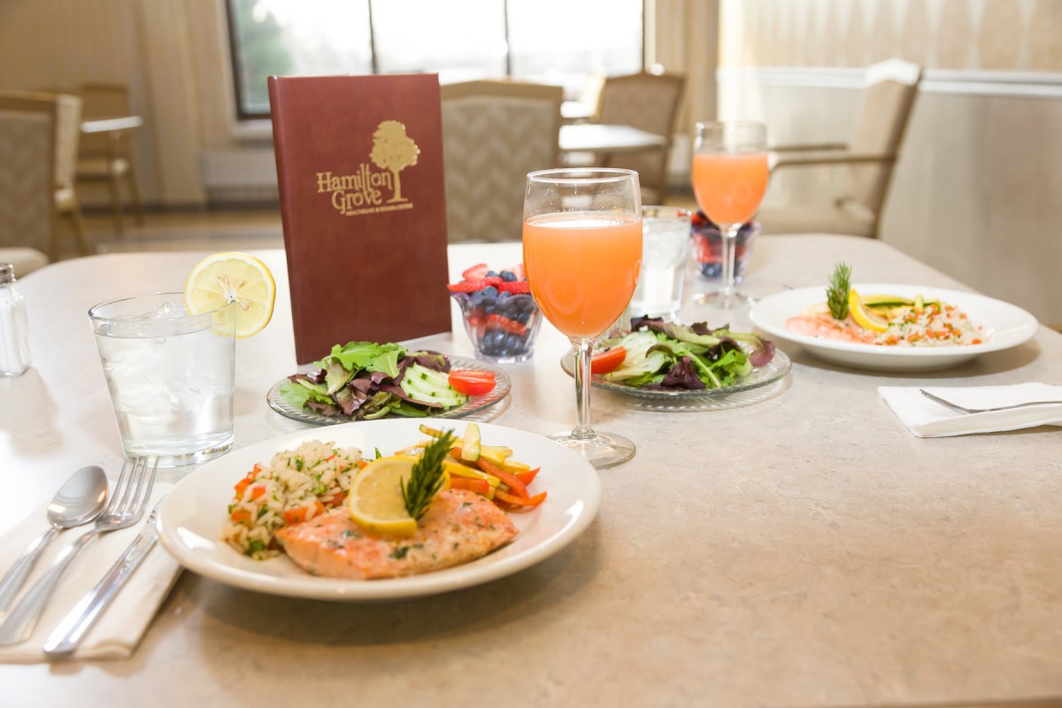 A beautifully presented meal featuring salmon, salad, and a refreshing beverage at a restaurant.