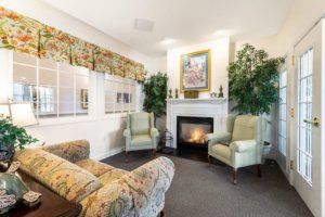 A cozy living room featuring a fireplace, armchairs, and elegant decor.