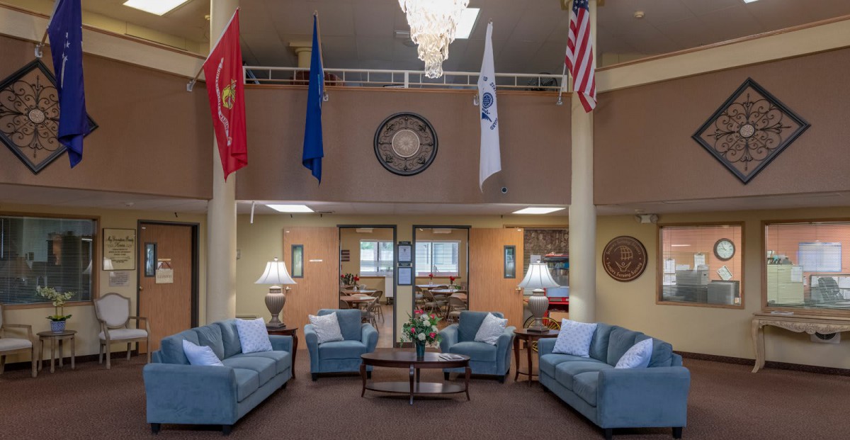 A cozy lobby area with comfortable seating and various flags displayed overhead.