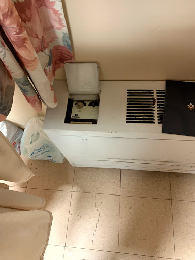 A view of a room featuring an air conditioning unit and curtains.