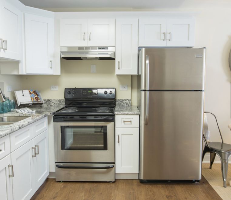 A modern kitchen with stainless steel appliances and white cabinets.