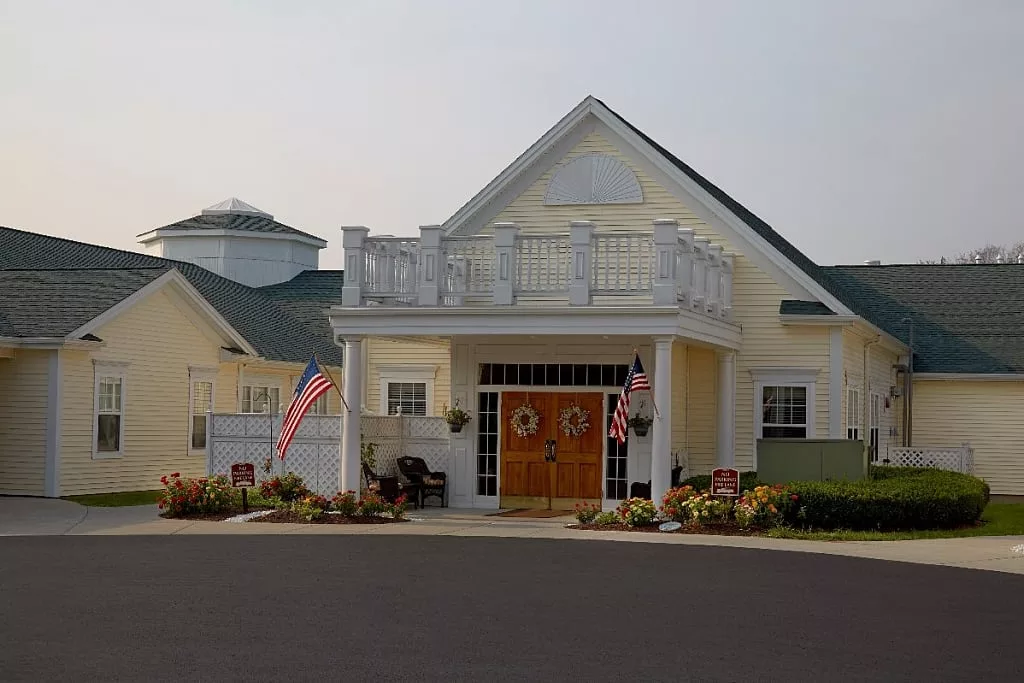 A residential building with flags at the entrance.