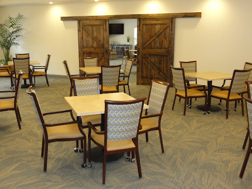 A spacious and modern dining area featuring wooden tables and chairs, with rustic barn doors in the background.