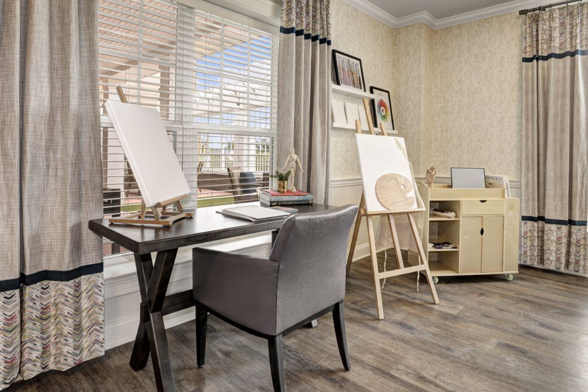 A cozy art studio with ample natural light and a well-organized workspace.