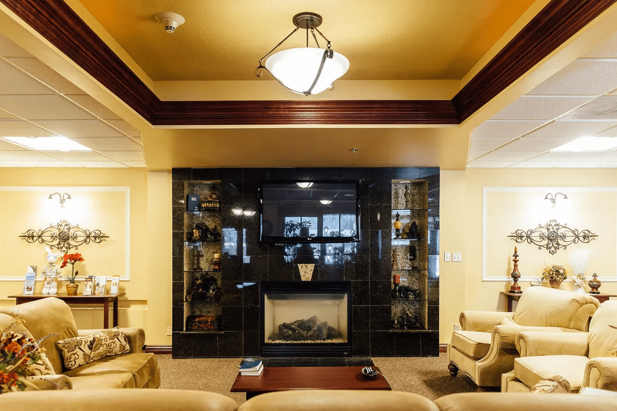 A cozy living room with a central fireplace and comfortable seating.