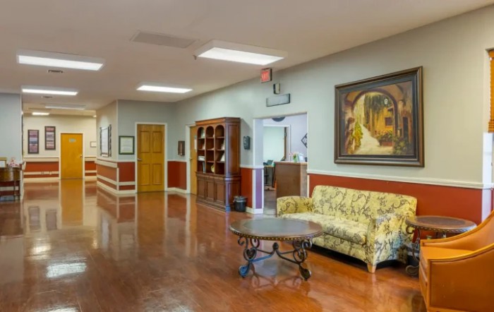A well-decorated hallway with a sofa, table, and artwork on the walls.