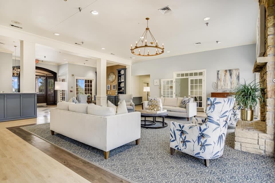 A modern and bright living room with elegant furnishings and a stylish chandelier.