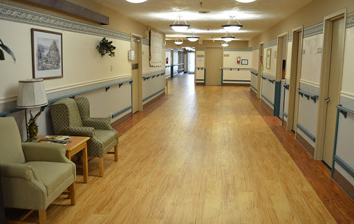 A spacious and well-lit healthcare hallway with seating areas.