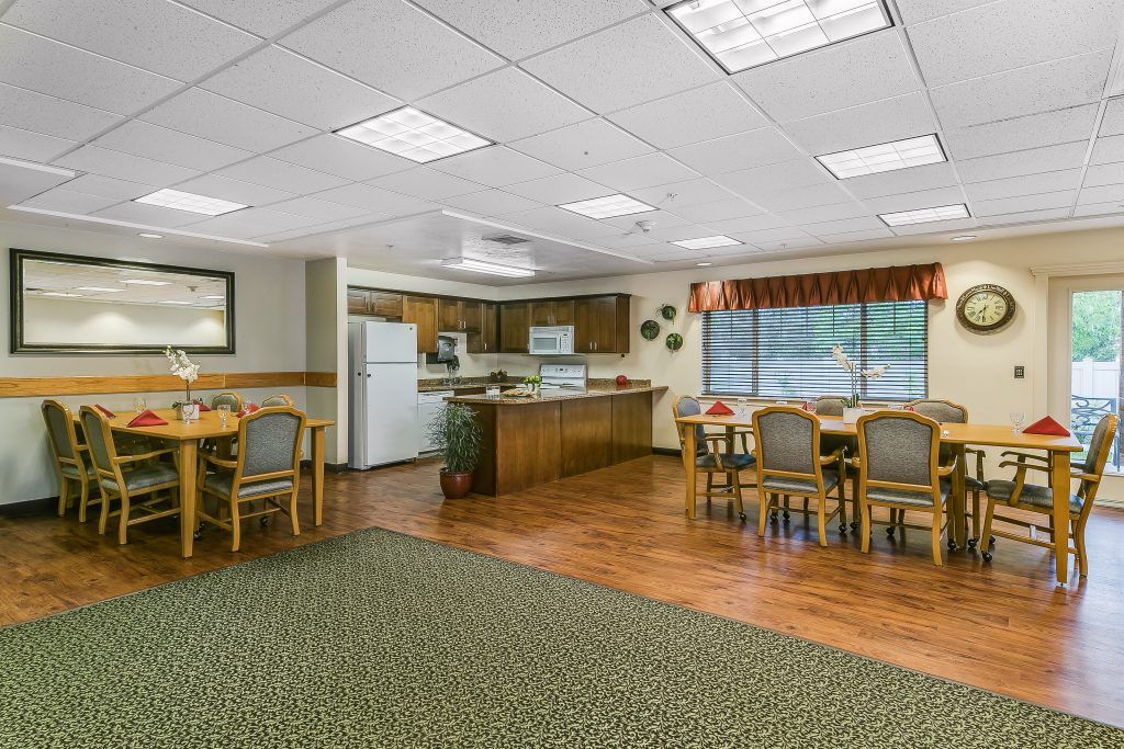A spacious kitchen and dining area with wooden flooring, equipped with modern appliances and comfortable seating.