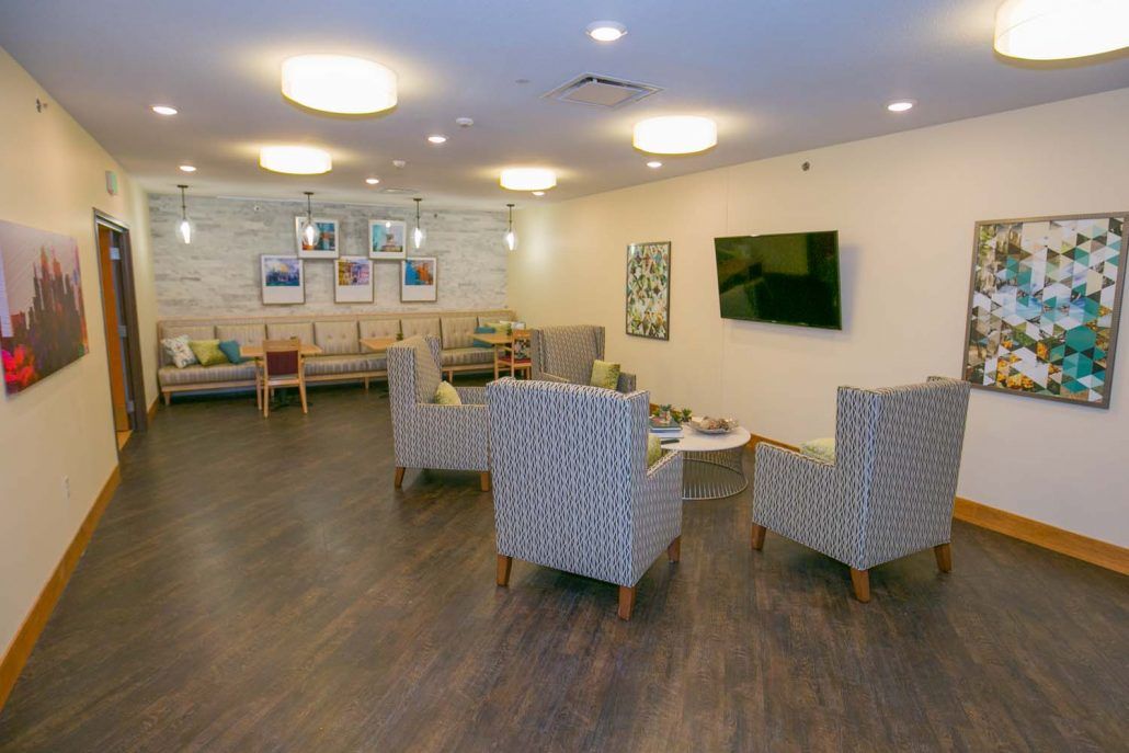A modern waiting room with comfortable seating and a television.