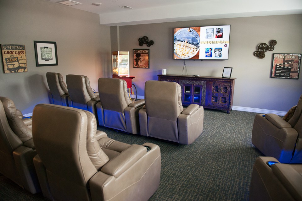 A cozy home theater setup with recliner chairs facing a large television screen, perfect for movie nights.