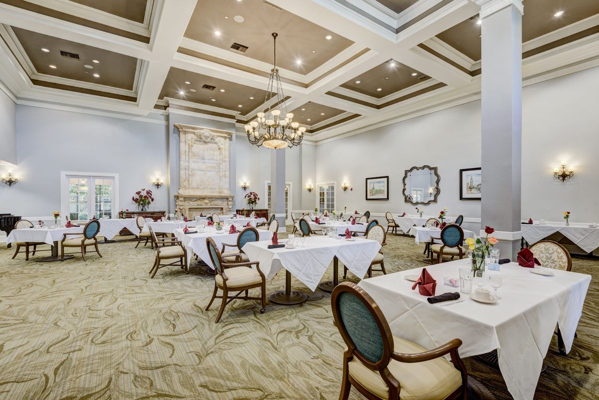 An elegant dining room with decorated tables and chandeliers.