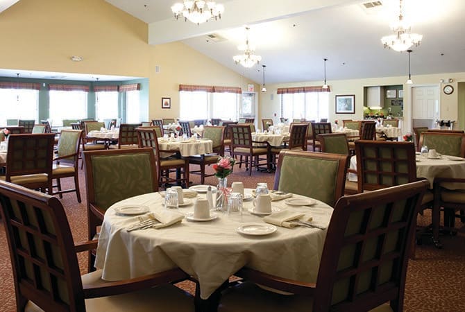 A well-set dining area with multiple tables and chairs, ready for guests.