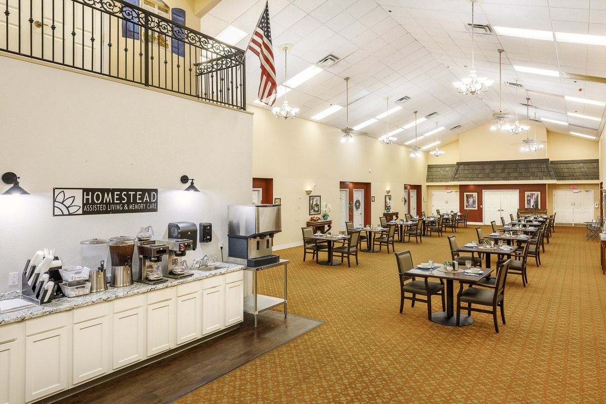 A spacious dining area with multiple tables and a beverage station.