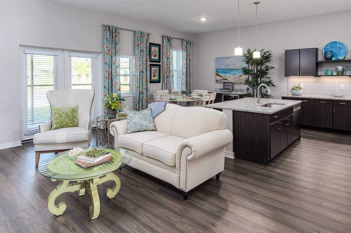 A modern open-concept living and dining area featuring a white couch, hardwood flooring, and stylish decor.