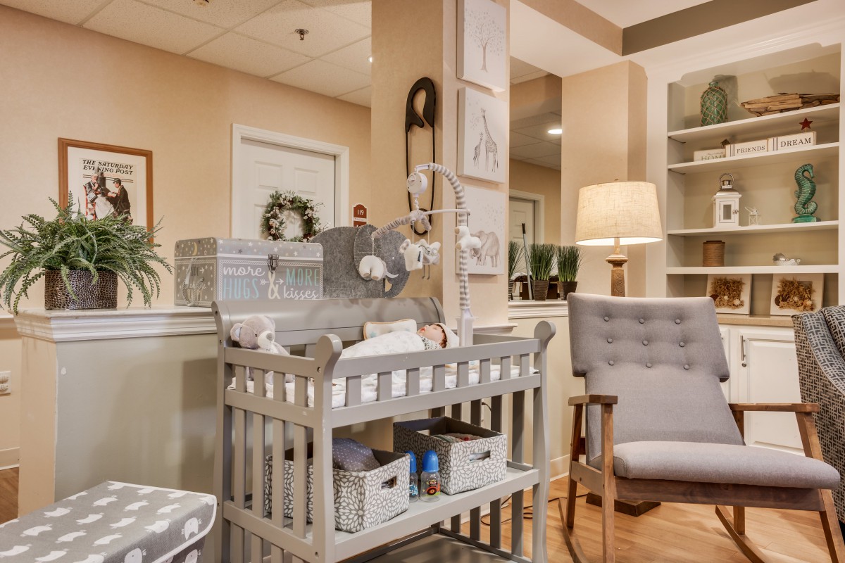 A cozy nursery featuring a stylish changing table and comfortable seating area.