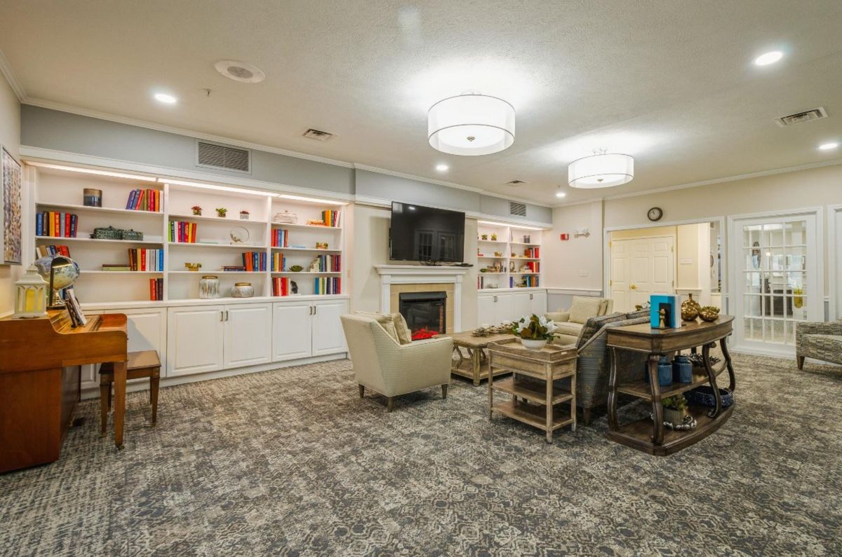 A cozy living room with a modern design featuring bookshelves, a fireplace, and comfortable seating.