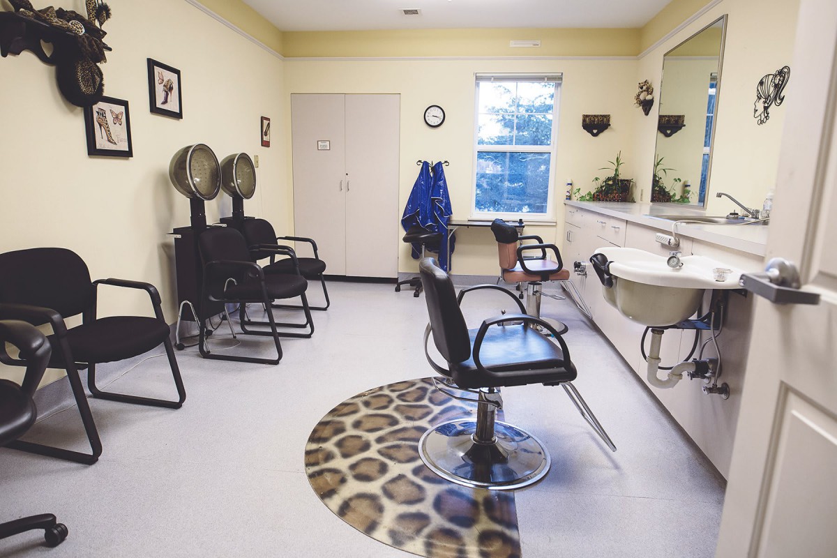 An interior view of a hair salon with empty chairs and styling stations.