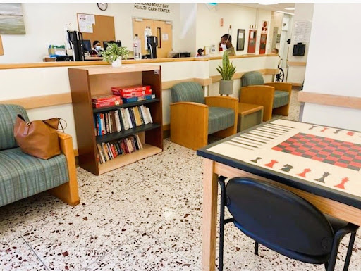 A cozy waiting area featuring comfortable seating, a bookshelf filled with books, and a checkers game for guests to enjoy.