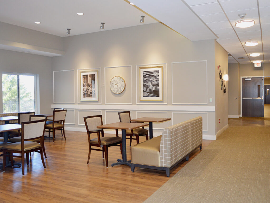 A cozy dining area with wooden flooring and artwork on the walls.