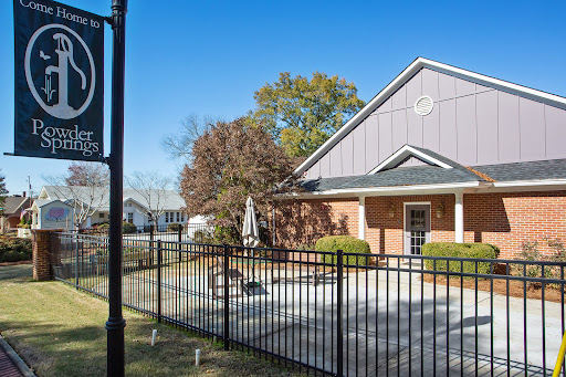 A charming residential home with a fenced patio area under a bright blue sky.